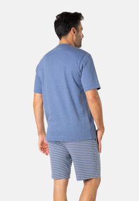 T-shirt en coton bleu à manches courtes, associé à un short gris à rayures. Les deux articles présentent une coupe décontractée et un design minimaliste.