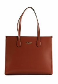Hnědá kožená taška přes rameno s dvěma ramenními popruhy. Mezi jejími vlastnostmi je hladký povrch a zlaté logo "GUESS" na přední straně. Žádné další vzory.