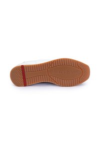 Semelle de chaussure de sport blanche avec un motif hexagonal texturé. Comprend une semelle extérieure en caoutchouc marron et une bande d'accent rouge.