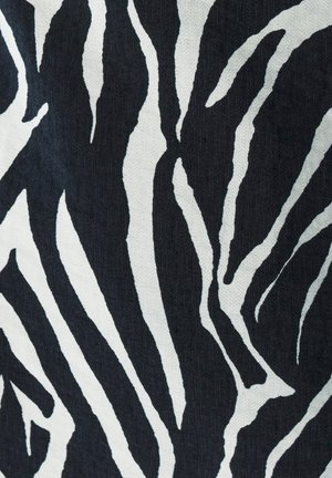 Textil s čiernobielym zebrovým vzorom s výraznými, zakrivenými pruhmi na textúrovanej ploche, zdôrazňujúci kontrast medzi farbami a vzormi.