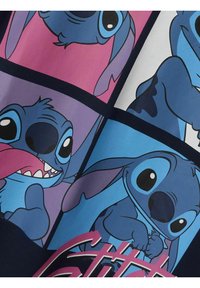 La tela de algodón azul presenta un gráfico multicolor de Stitch en varias poses, contorneado en negro, con texto en rosa integrado en el diseño.
