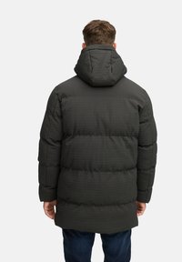 Mørkegrøn pufferjakke med et textured, quiltet mønster, der har hætte og en afslappet pasform. Velegnet til koldt vejr.