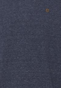 Marineblauwe, gestructureerde stoffen t-shirt met een klein bruin logo-accent. Het materiaal vertoont een subtiele heather-patroon met een zachte afwerking.