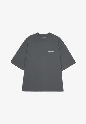 Gray oversized t-shirt made of cotton with a crew neck and short sleeves, featuring a small white logo on the front.