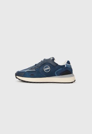 Marineblaue Sportschuhe mit Mesh- und Wildlederakzenten, rundem Logo, gepolstertem Schaft, strukturiertem Sohlenprofil und kontrastierender hellfarbiger Mittelsohle.