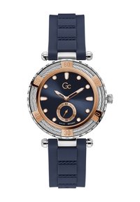 Marinblå silikonarmbandsur med ett hus i rostfritt stål, en mörkblå urtavla, roséguldiga accenter och en strukturerad bezel med minutmarkeringar.