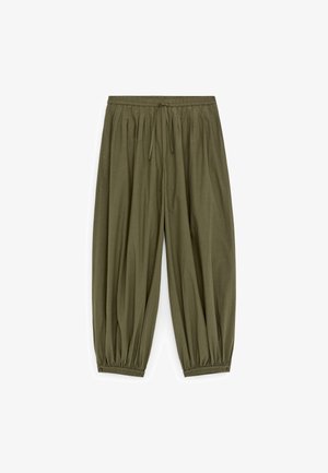 Luźne spodnie w kolorze oliwkowej zieleni z elastycznym pasem i ściągaczami przy kostkach, wyposażone w sznurek do wiązania w talii.