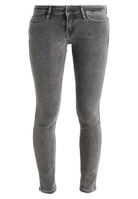 Jeans skinny de mezclilla gris con una textura suave, cinturilla de altura media y diseño clásico de cinco bolsillos. Detalles de desgaste sutil en toda la prenda.