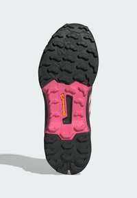 Schwarze und rosa Sportschuhsohle mit aggressivem Profil, ausgestattet mit einer rosa Zwischensohle und dem Continental-Logo auf dem Gummi.