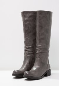 Bottes gris hauteur genou en cuir synthétique avec un design froissé, bout arrondi et petit talon bloc. Fermeture éclair latérale pour un enfilage facile.