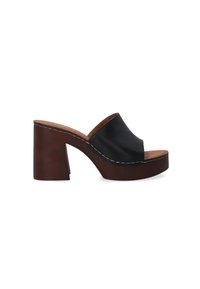 Zwarte leren platform mules met een open teen, een bruine blokhak en witte stiksel details langs de rand. Gladde textuur en gebogen ontwerp.