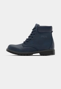 Bottines en simili cuir bleu marine avec un bout rond, des lacets à l'avant, un col rembourré et une semelle en caoutchouc robuste. Logo Fila embossé sur le côté.