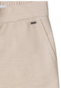 Pantalon beige en tissu texturé avec une ceinture élastique, doté de poches latérales et d'un petit logo métallique.