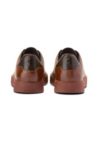 Bruine leren sneakers met een gladde textuur, ronde vorm en een contrasterende donkerbruine hielcap. Beschikt over een verhoogd logo en rubberen zool.