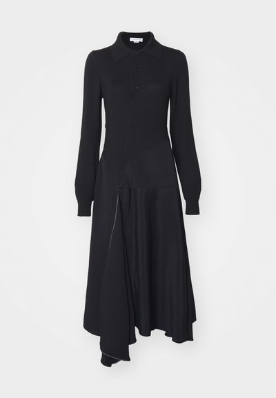 Melnas kleitas ar garām piedurknēm, apkakli, pogu priekšpusi. Materiāls ir jaukts, sastāv no teksturēta adījuma un gluda auduma, asimetrisks apakšmalā un sudraba rāvējslēdzis detaļās.