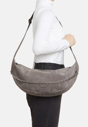 Wildledergraue Schultertasche mit geschwungener Form, Kettenakzent und zwei Reißverschlusstaschen. Verstellbarer Riemen und Logo auf der Vorderseite.