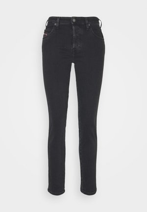 Jean slim noir taille haute avec poches avant, passants pour ceinture et fermeture par boutons, présenté sur fond blanc.