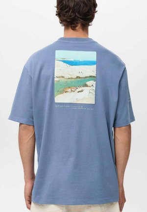 Short-sleeved blue cotton t-shirt featuring a rectangular graphic of a beach scene on the back, with text below the image.