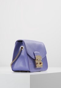 Bolso de cuero morado con forma estructurada, con cierre de bloqueo en tono dorado y correa de cadena. Exterior texturizado con cierre de solapa.