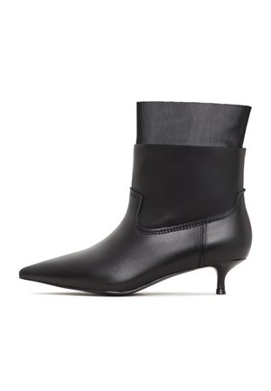 Sort ankelstøvle med spids tå, slankt læderdesign og meshmanchet; har en lille kitten heel og diskrete syninger.
