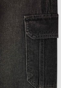 Jeans in denim nero con tasca frontale dotata di pattina angolare, cuciture in vista e superficie liscia, leggermente testurizzata.
