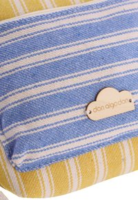 Bolsa textil a rayas azules y amarillas con una etiqueta de madera grabada con "don algodón". Incluye rayas horizontales y verticales en contraste.