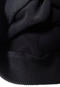 Tessuto in pile nero con una consistenza morbida, caratterizzato da un polsino a coste sul fondo. Il materiale ha una finitura liscia ed è leggermente stropicciato.