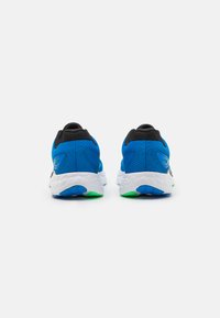 Blauwe sportieve schoenen met een zwarte mesh hiel, witte gevoerde zolen en groene accenten; voorzien van logo-details en een gestructureerd materiaal.