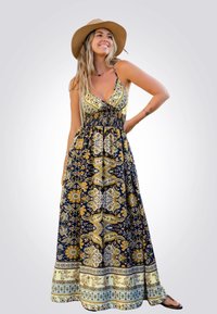 Vestido maxi con escote en V profundo, base azul marino, patrones florales y de paisley en amarillo y dorado. Presenta una cintura fruncida y una falda fluida.