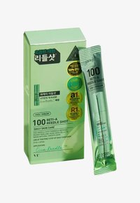 Grönförpackad hudvårdsprodukt med etiketten "100 RETI-A REEDLE SHOT", som har en genomskinlig tube som innehåller serum, präglad text och certifieringssymboler.