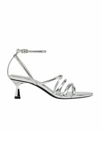 Sandale argentée à lanières avec une fine bride à la cheville, finition métallique, petit talon kitten et design ouvert à l'avant. Accent de talon noir.