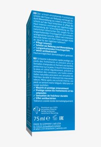 Emballage bleu pour baume pour pieds, 75 ml. Texte en allemand et en français décrivant les avantages d'utilisation. Fabriqué en aluminium écologique.