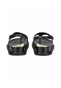 Černé sandály s hladkým koženým svrškem, nastavitelným řemínkem na kotníku a plochou podrážkou; zdobeny zlatými kovovými detaily a švy.