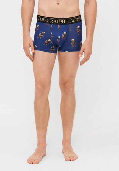 Bóxer para hombre en azul marino con cinturilla elástica, que presenta el logo "POLO RALPH LAUREN" y está decorado con gráficos de un oso de dibujos animados por toda la prenda.