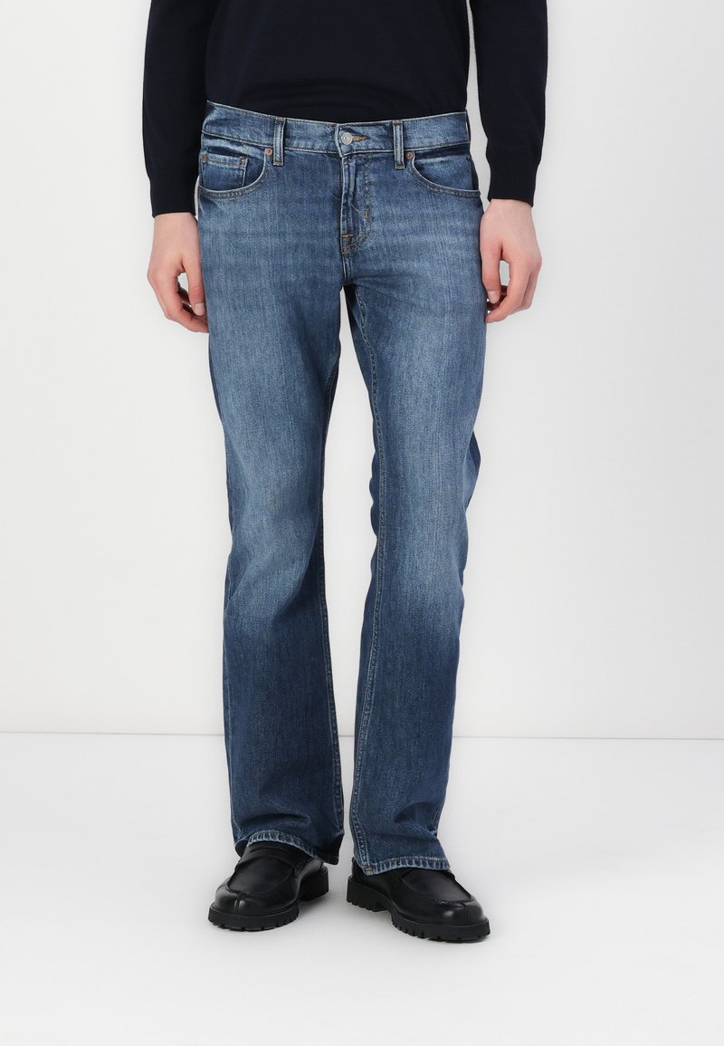 Men's blue denim jeans with a straight leg design, five pockets, and a button and zipper closure. Smooth texture with slight fading.