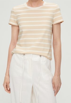 Beige og hvid kortærmet skjorte med vandrette striber kombineret med hvide, højttaljede bukser med snore.