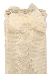 Calze lavorate a maglia beige fino al ginocchio con un motivo testurizzato e un fiocco decorativo a pois dorati chiari sulla parte superiore. Materiale morbido.