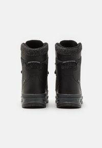 Schwarze wasserdichte Wanderschuhe mit einem strukturierten grauen Kragen, verstärktem Absatz und profiliertem Gummisohle, ausgestattet mit seitlichen Reißverschlüssen und Logo-Akzenten.