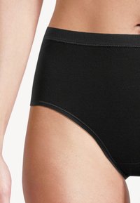 Slip neri a vita alta realizzati in tessuto liscio e elastico, con una vita senza cuciture e cuciture sottili, che offrono una vestibilità aderente.