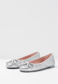 Ballet flats glitterati argento con punta arrotondata, dettaglio a fiocco in corda e interno rosa. Suola piatta con finitura liscia.
