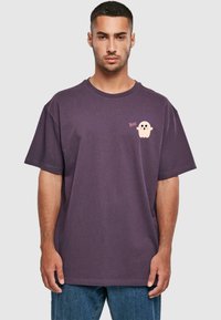 Lilla bomulds-T-shirt med rund halsudskæring, korte ærmer og et tegneserie-spøgelse grafik med "Boo!" tekst på venstre bryst.