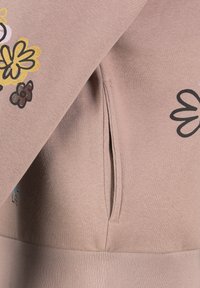 Roze sweatshirt gemaakt van zacht stof met bloemenprints in geel, roze en bruin. Voorzien van een zijzak en een geribde zoom.