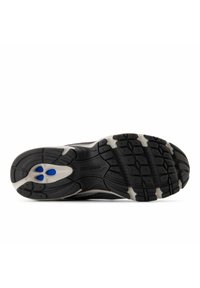 Black athletic shoe outsole with a textured surface, featuring a white midsole and blue accents, designed for traction and durability.