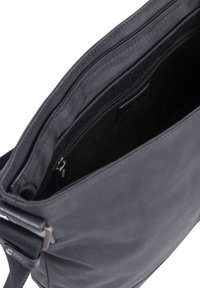 Borsa a spalla in tessuto nero con una cerniera superiore parzialmente aperta, che rivela una tasca interna con cerniera e un manico con hardware in metallo.