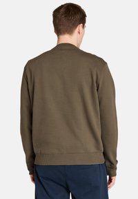 Sudadera verde oliva con cuello redondo y dobladillo acanalado. Tela de algodón suave, con una textura lisa y un diseño minimalista.