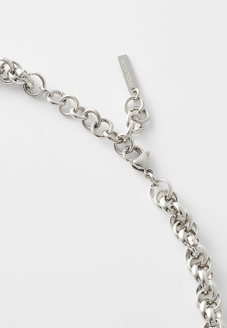 Bracelet en chaîne en métal argenté avec de grands maillons ronds et un fermoir, agrémenté d'une petite étiquette gravée "POLICE". Texture lisse sur l'ensemble.