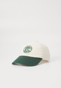 Baseball-Mütze mit einer cremigen Krone und einem dunkelgrünen Schirm. Enthält ein gesticktes, kreisförmiges Logo in grün. Aus Baumwollmaterial, strukturierte Form.