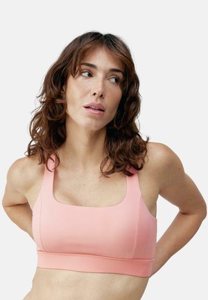 Roze sportbeha van soepel materiaal, met een vierkante halslijn, brede schouderbanden en een elastische band aan de onderkant.