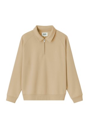 Pull beige avec col zippé, manches raglan et texture douce. Dispose d'un petit logo sur la poitrine et d'une coupe décontractée.