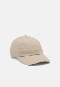 Beige cotton cap with a curved brim, six-panel design, and embroidered logo on the front, featuring ventilation eyelets for breathability.